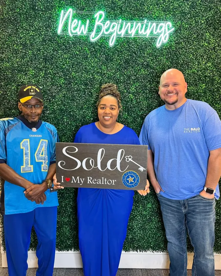 Joey with clients holding Sold signs