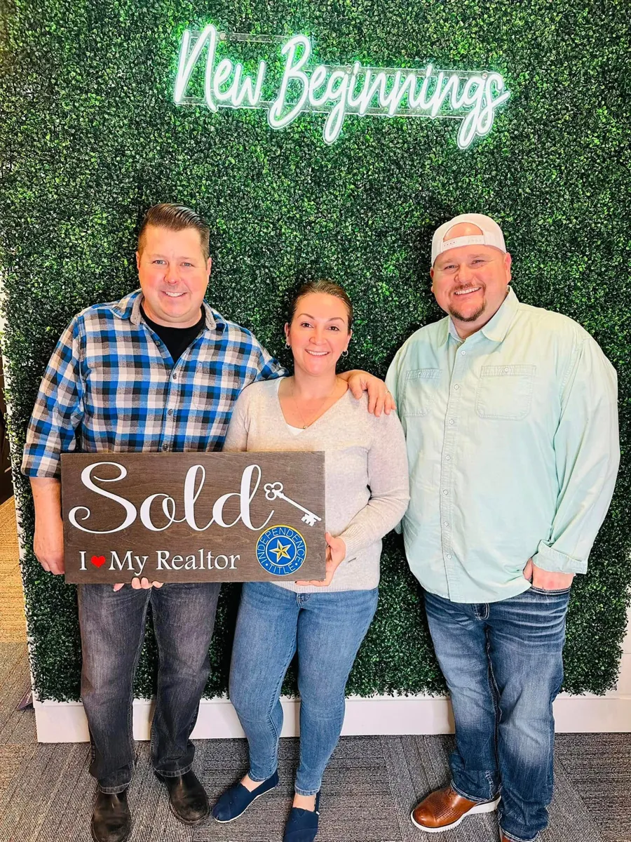 Joey with clients holding Sold signs